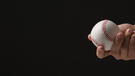 Nahaufnahme-Einer-Hand,-Die-Einen-Baseballball-Vor-Schwarzem-Hintergrund-Wirft-Und-Fängt
